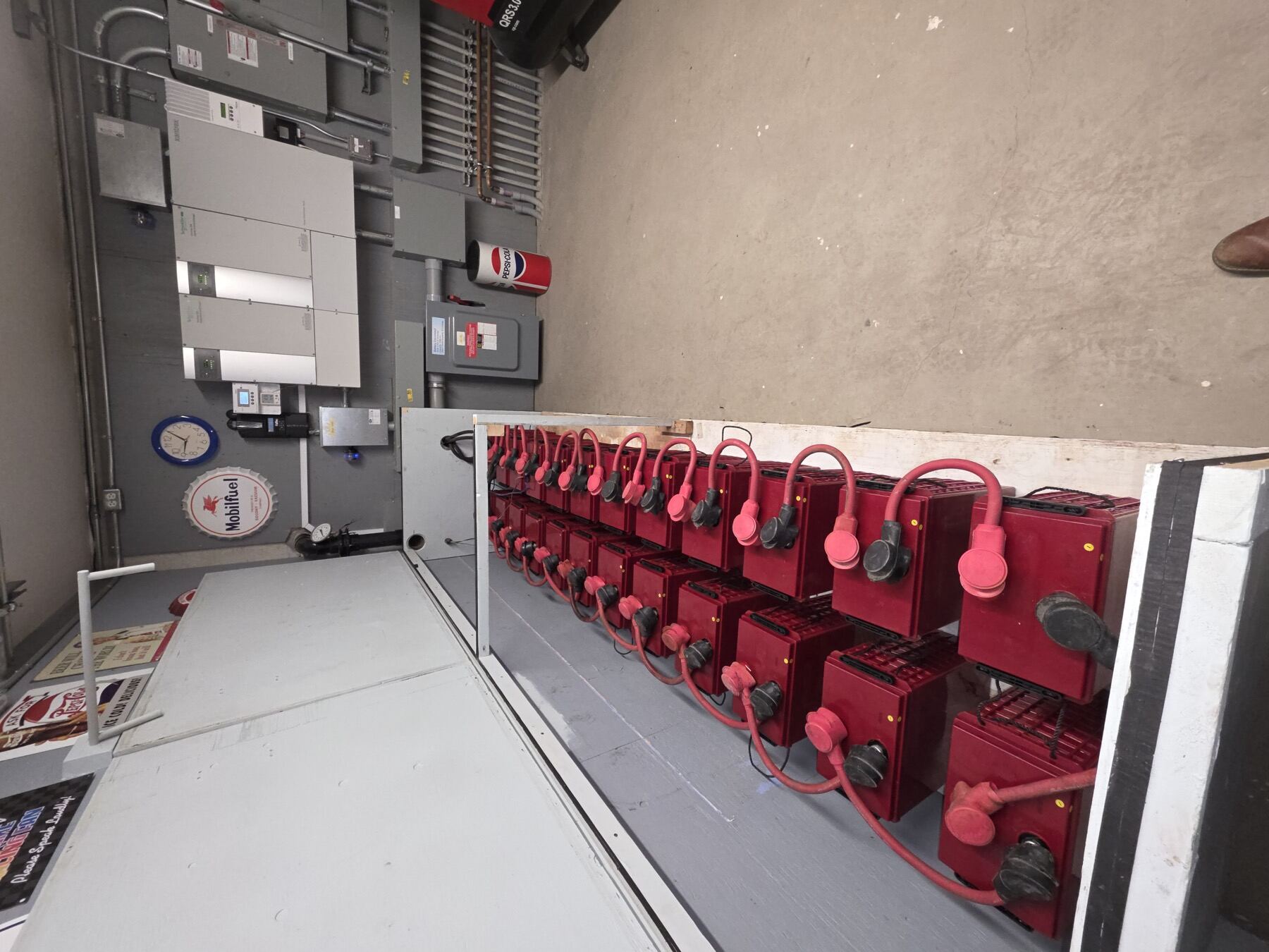 An off-grid battery bank and inverter installation by Riverstone Electric, with labelled cabling runs